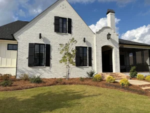 A white brick house with black shutters, an arched entryway, and house number 400.