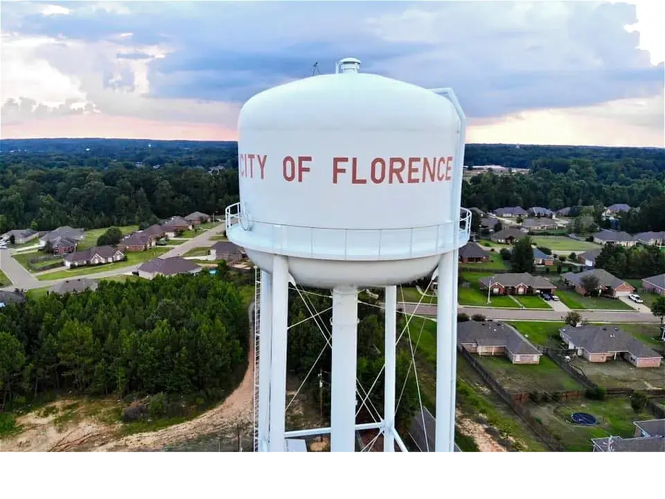 A white water tower labeled City of Florence overlooking a suburban neighborhood.