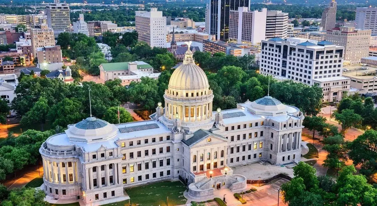 Aerial view of the Mississippi State Capitol building in Jackson surrounded by trees and city buildings.
